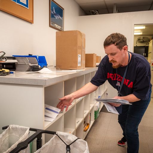 Man placing mail on shelf